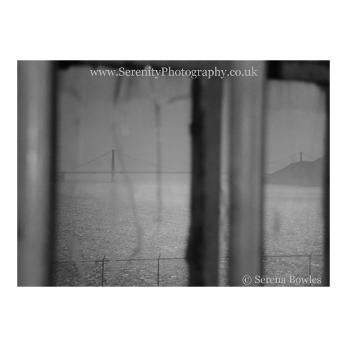 A view of the Golden Gate Bridge as seen through a cracked and barred window from Alcatraz Prison. San Francisco, USA
